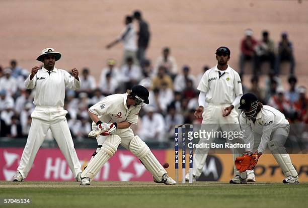 Paul Collingwood of England watches as the ball dislodges a bail as Verender Sehwag, Rahul Dravid, and Mahenrda Dhoni look on during the second day...