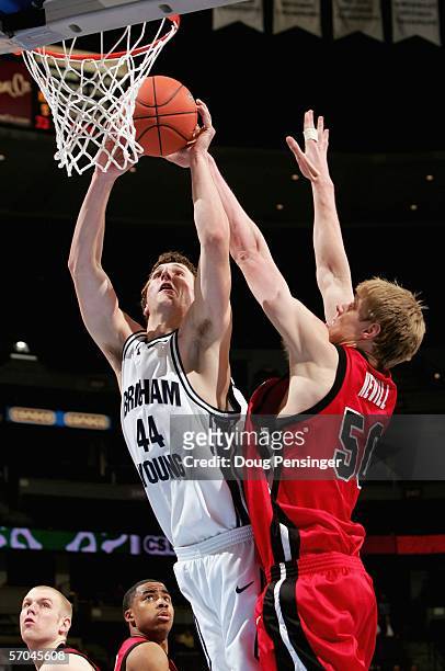 Trent Plaisted of the Brigham Young University Cougars tries to get off a shot against Luke Nevill of the Utah Runnin' Utes as the Utes upset the...