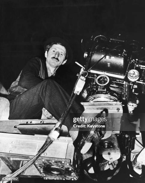 Albanian photographer and director Gjon Mili on a camera crane on the set of his film 'Jammin' The Blues', which features celebrated jazz musicians,...