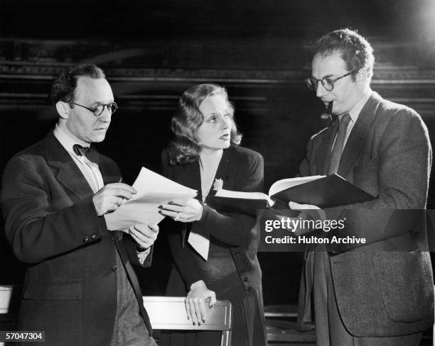 American playwright and screenwriter Clifford Odets , who smokes a pipe, looks at a manuscript and offers his opinion to American actress Tallulah...