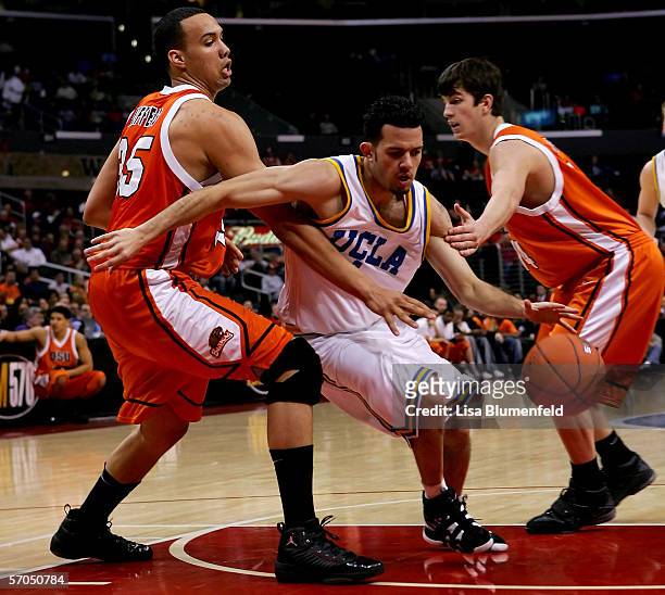 Jordan Farmar of the UCLA Bruins moves through the defense of Kyle Jeffers and Jack McGillis of the Oregon State Beavers during the quarterfinals of...