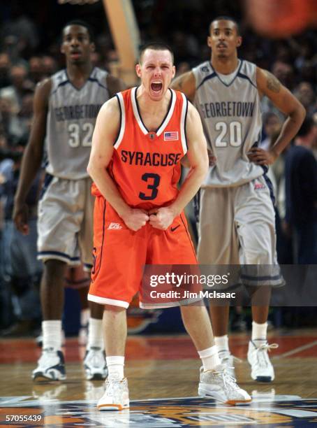 Gerry McNamara of the Syracuse Orange celebrates after the final basket by Syracuse to win the game as Jeff Green and Darrel Owens of the Georgetown...