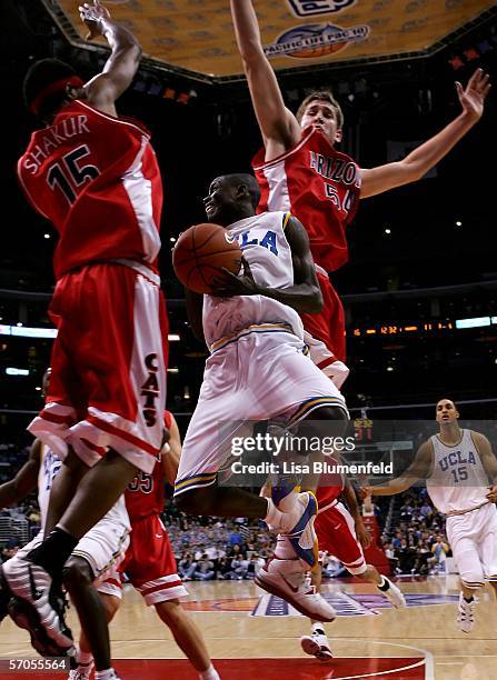Darren Collison of the UCLA Bruins goes up against Mustafa Shakur and Kirk Walters of the Arizona Wildcats during the semifinals of the 2006 Pacific...