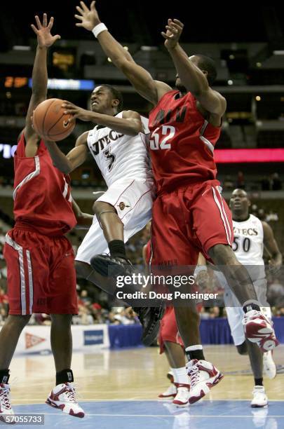 Richie Williams of the San Diego State University Aztecs goes to the basket between Ricky Morgan and Gaston Essengue of the UNLV Runnin' Rebels...