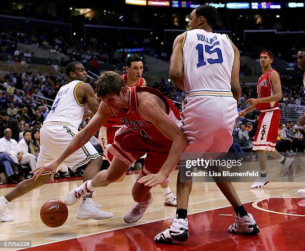 Kirk Walters of the Arizona Wildcats loses control of the ball under pressure from Ryan Hollins of the UCLA Bruins during the second half of their...