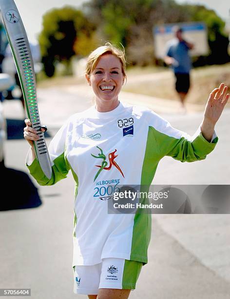 Actress Rebecca Gibney waves as she carries the Melbourne 2006 Queen's Baton as part of the Melbourne 2006 Commonwealth Games Queen's Baton Relay...