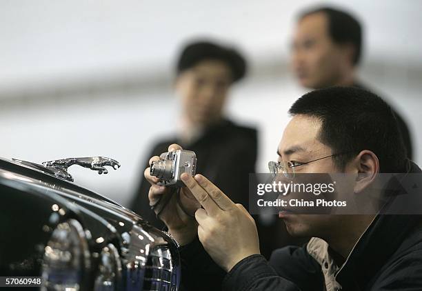 Visitor takes pictures of a Jaguar logo at the Imported Auto Expo Shanghai 2006 at the Shanghai Automobile Exhibition Center on March 11, 2006 in...