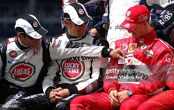 Rubens Barrichello of Brazil and Honda Racing puts a sticker with his name on the overall of his former team mate Michael Schumacher of Germany and...