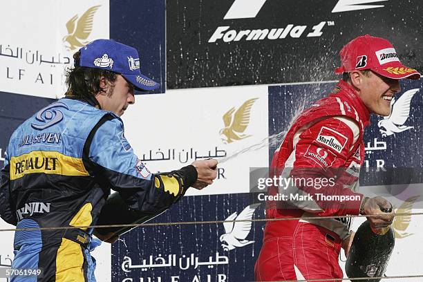 Fernando Alonso of Spain and Renault sprays Michael Schumacher of Germany and Ferrari on the podium during the Bahrain Formula One Grand Prix at the...