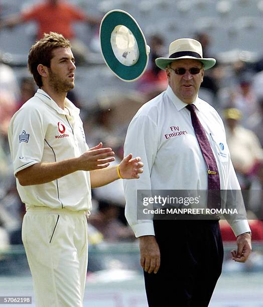 England cricketer Liam Plunkett play's with his hat as umpire Darrel Hair looks on during the fourth day of the second Test match between India and...