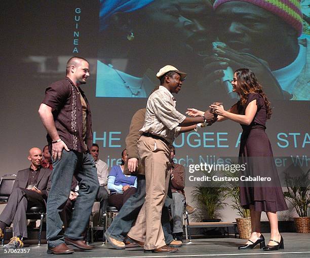 Ruben of The Refugee All Stars accepts his award from emcee Alicia Braga at the Miami International Film Festival awards ceremony at the...