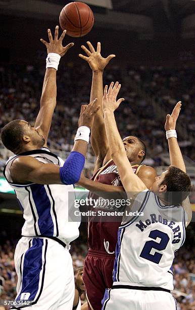 Craig Smith of the Boston College Eagles shoots over Shelden Williams and Josh McRoberts of the Duke Blue Devils during the finals of the Atlantic...