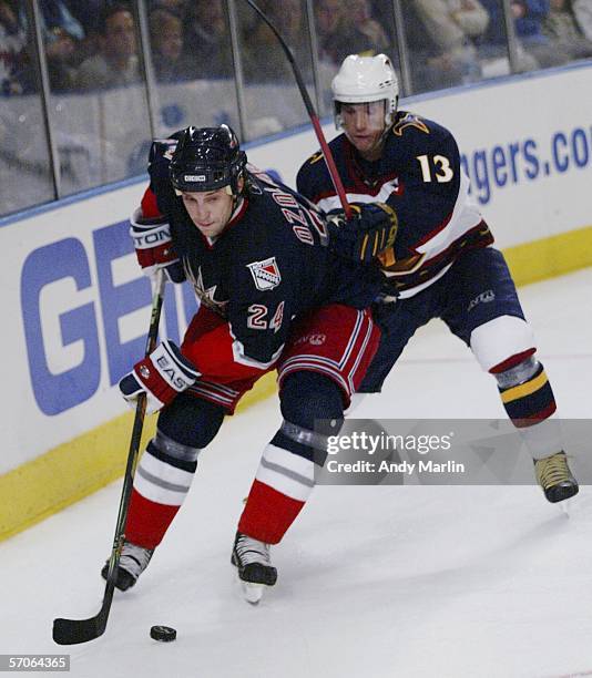 Sandis Ozolinsh of the New York Rangers plays the puck against Vyacheslav Kozlov of the Atlanta Thrashers at Madison Square Garden on March 12, 2006...