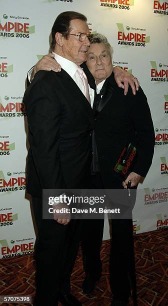 Actors Roger Moore and Tony Curtis pose in the awards room with the Empire Lifetime Achievement Award presented to Curtis by Moore at the Sony...