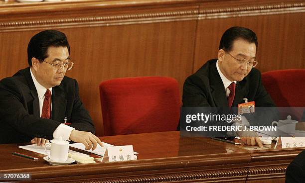 Tope leaders of the Chinese Communist Party President Hu Jintao and Premier Wen Jiabao motion to push the button during a vote at the last sesison of...