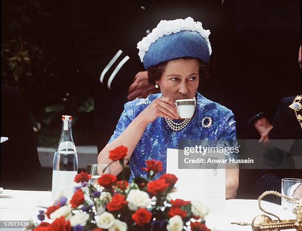 Queen Elizabeth ll has a cup of tea while in Northern Ireland on a royal visit in 1977.