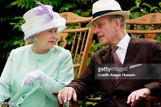 Queen Elizabeth II and Prince Phillip the Duke of Edinburgh chat while seated during a musical performance in the Abbey Gardens, Bury St Edmunds...
