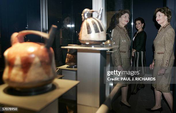 Washington, UNITED STATES: US First Lady Laura Bush is reflected in a display case as, Mexican First Lady Marta Sahagun de Fox watches during a tour...