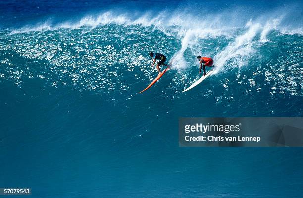 two surfers riding a huge wave - championship day two stock-fotos und bilder