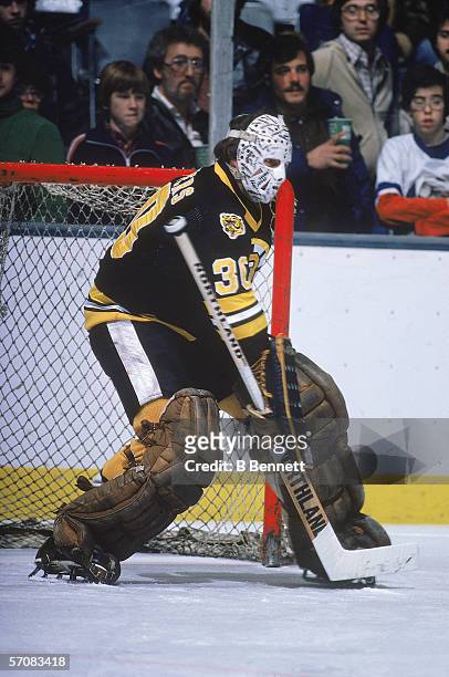 Canadian professional hockey player Gerry Cheevers of the Boston Bruins defends the goal on the ice during a road game, late 1970s.