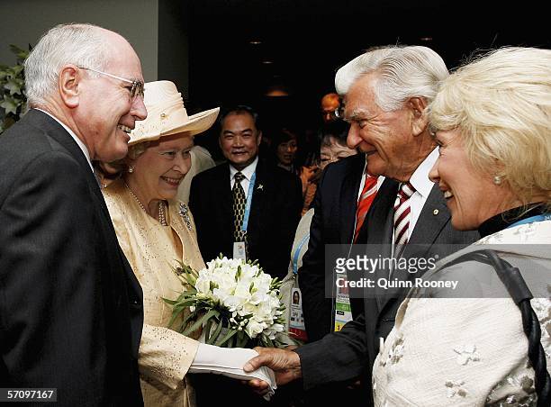Her Majesty Queen Elizabeth II shakes hands with former Australian Prime Minister Bob Hawke as his wife Blanche D'Alpuguet and current Australian...