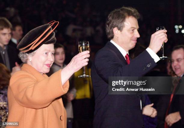 Queen Elizabeth II and British Prime Minister Tony Blair raise their glasses as midnight strikes during the Opening Celebrations on December 31, 1999...
