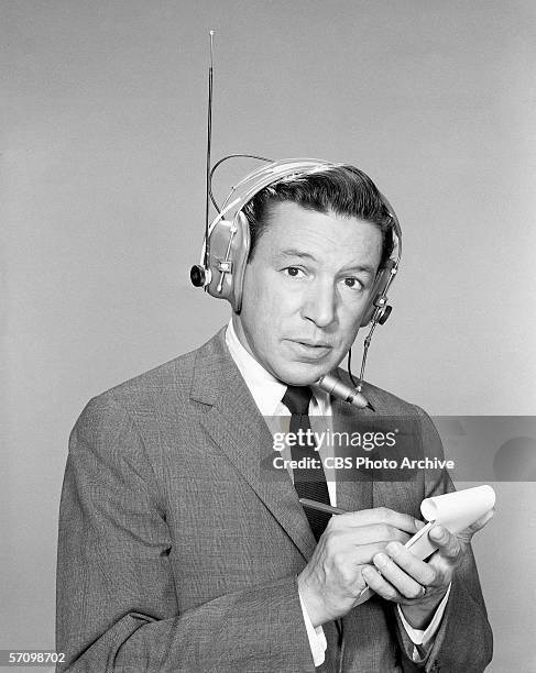 Publicity portrait of American broadcast journalist Mike Wallace, who wears a wireless headset and holds a pad and pen ready, May 7, 1964. Wallace is...