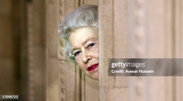 Queen Elizabeth II peers round a corner of the Royal Albert Hall during a tour of the concert hall to mark the completion of the eight year building...