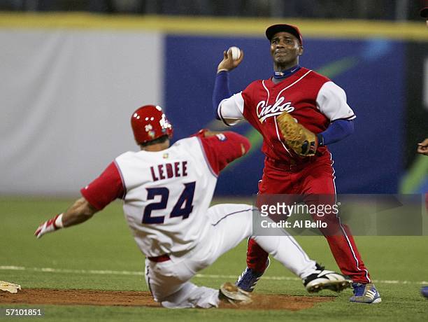 Eduardo Paret of Cuba throws to complete a double play as Ricky Ledee of Puerto Rico slides during Round 2 of the World Baseball Classic on March 15,...