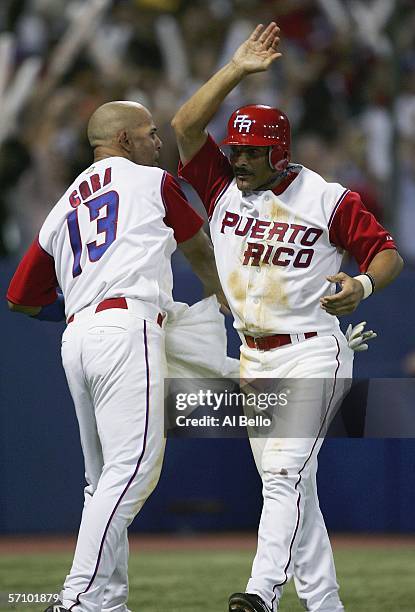 Jose Valentin of Puerto Rico celebrates with teammate Alex Cora after scoring a run against Cuba during Round 2 of the World Baseball Classic on...