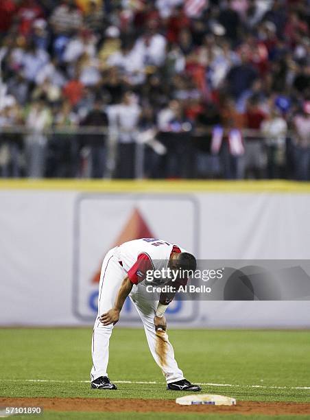 Alex Cintron of Puerto Rico hangs his head after hitting into a double play with two men in scoring position in the eighth inning against Cuba during...