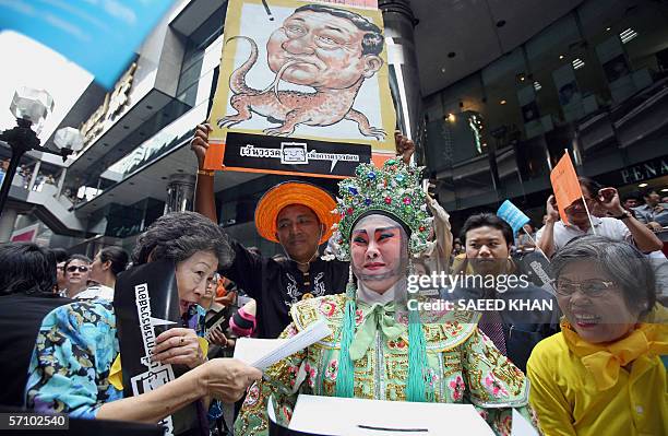 Protestor clad in a Chinese Opera costume holds a box to collect funds for the current anti Thai Prime Minister Thaksin Shinawatra's campaign at a...