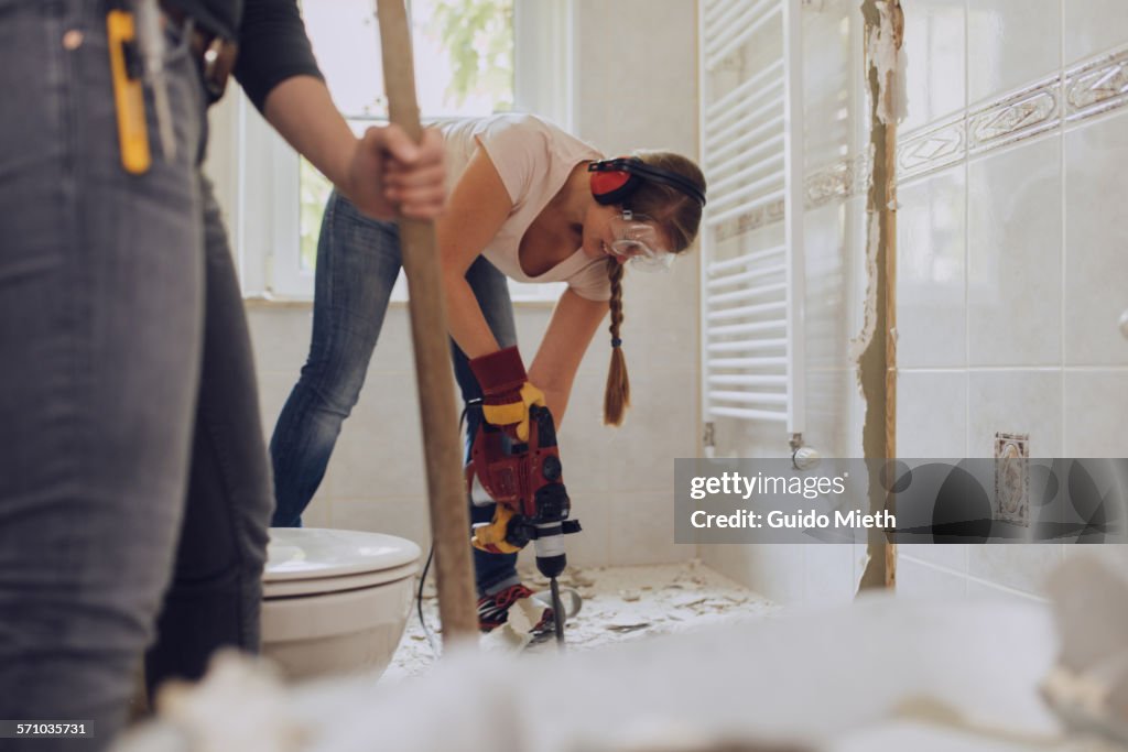 Women refurbishing bathroom.