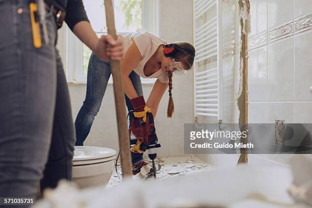 women refurbishing bathroom. - 革新 個照片及圖片檔
