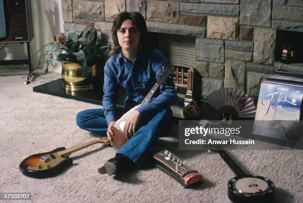 American glam rock singer and bassist Suzi Quatro with a collection of string instruments, circa 1975. On the right is a copy of ZZ Top's album...