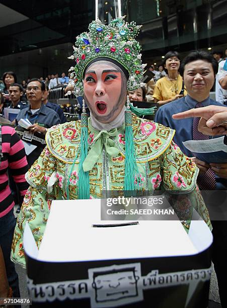 Protestor clad in a Chinese opera costume holds a box to collect funds for the current anti Thai Prime Minister Thaksin Shinawatra's campaign at a...
