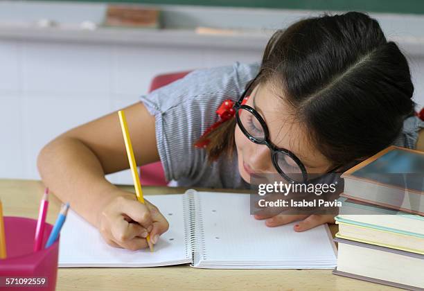 girl doing homework in classroom - escuela rural fotografías e imágenes de stock