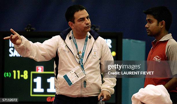 India's table tennis Subhajit Saha listens to his coach during his game against Northern Ireland's Andrew Dennison during the men's preliminary round...
