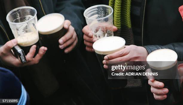 Cheltenham, UNITED KINGDOM: Race-goers at Cheltenham drink pints of Guinness as they celebrate St. Patrick's Day before the start of the Gold Cup...