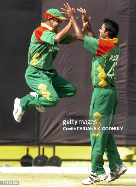 Bangladeshi cricketers Syed Rassel and Habibul Bashar celebrate the dismissal of unseen Kenyan batsman Stephen Tikolo during the first One Day...