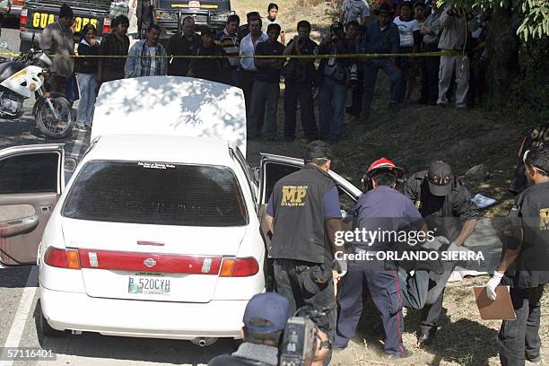 Agentes del Ministerio Publico y miembros del Cuerpo de Bomberos Muncipales retiran de un vehiculo de turismo los cadaveres de cuatro hombres...