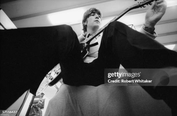 John Lennon tunes his guitar in his dressing room at the Nippon Budokan in Tokyo, during the Beatles' Asian tour, 2nd July 1966.