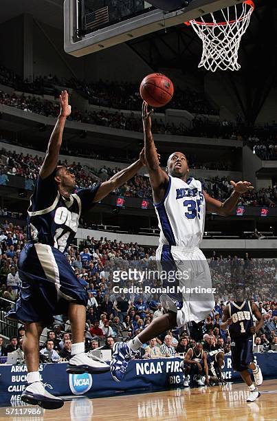 Darius Washington Jr. #35 of the Memphis Tigers goes up for a shot as Jonathan Bluitt of the Oral Roberts Golden Eagles attempts the block during the...