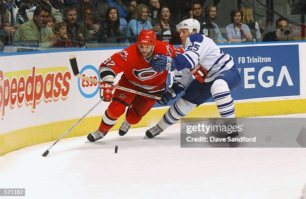 Jeff O'Neill of the Carolina Hurricanes is held as he tries to skate away from Jyrki Lumme of the Toronto Maple Leafs during game four of the Eastern...