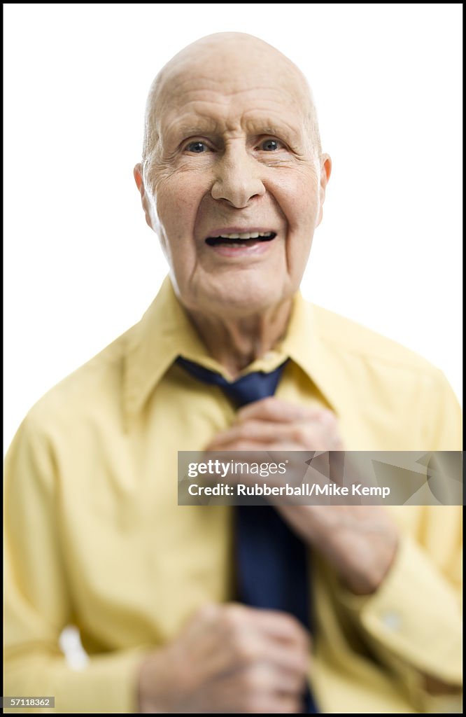 Portrait of a senior man adjusting his tie