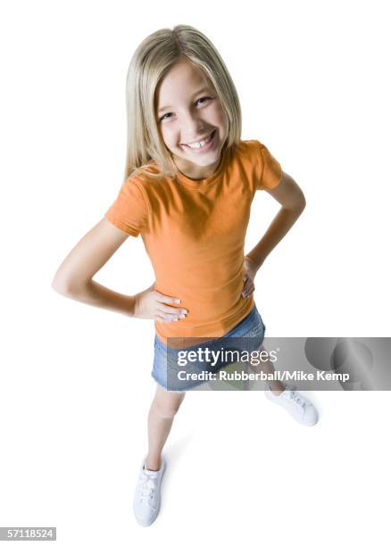 portrait of a girl standing with her hands on her hips and smiling - piernas separadas fotografías e imágenes de stock