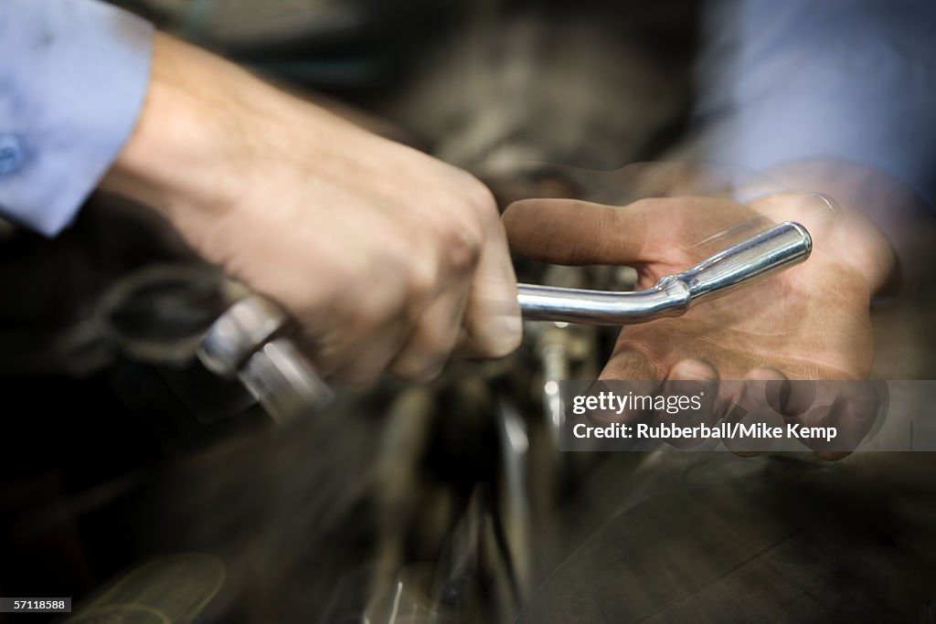 Man giving a spanner to another man