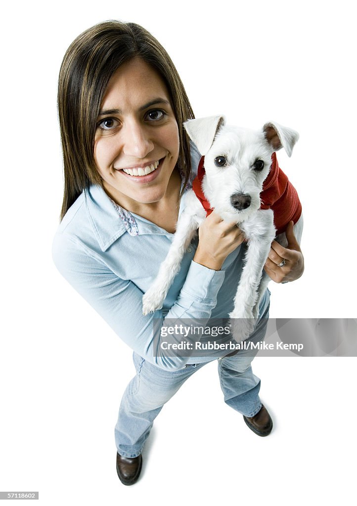 Portrait of a young woman holding a dog in her arms