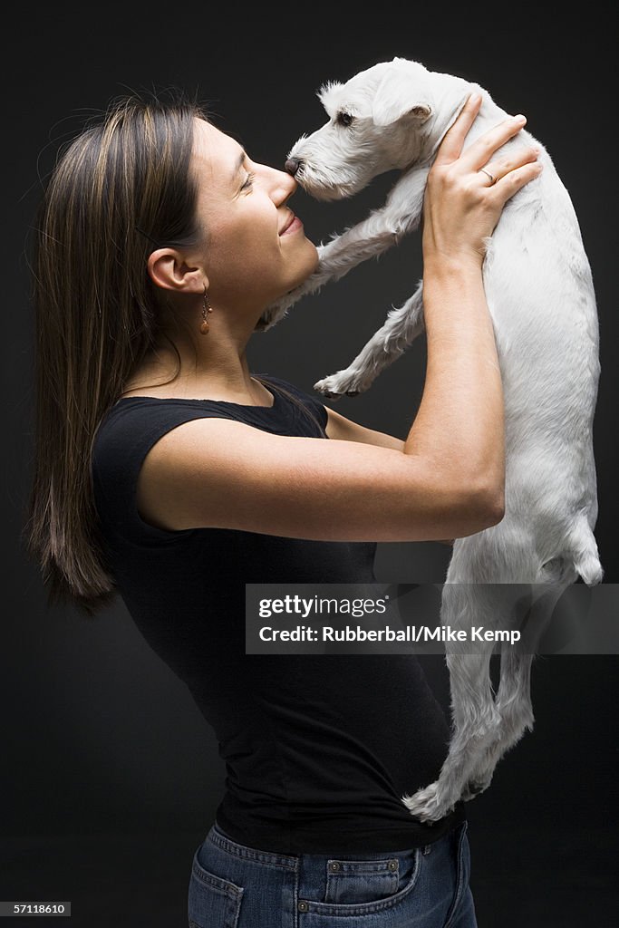 Profile of a young woman playing with her dog