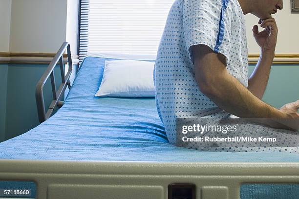 mid section view of a patient sitting on a hospital bed - mike storen stock-fotos und bilder